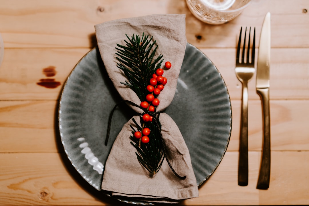 flat lay photography of a table napkin on top of a plate beside fork and knife