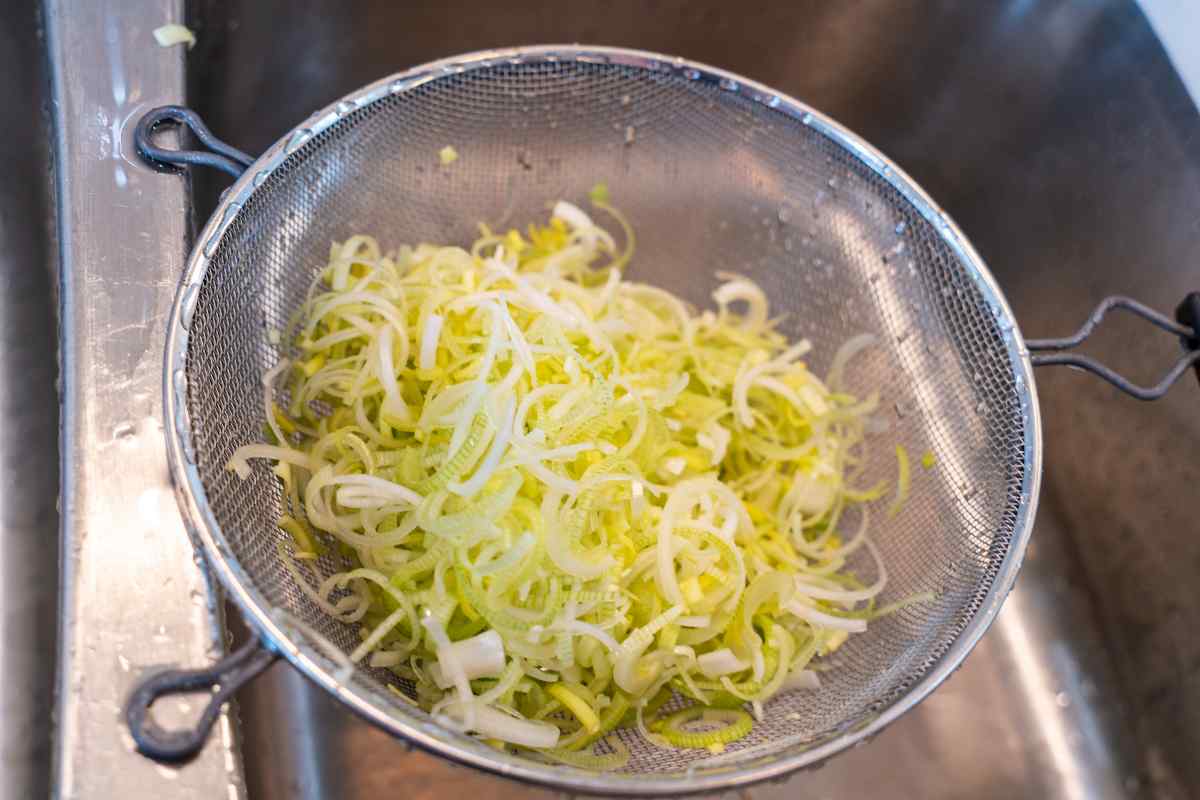 Image of some leeks chopped and rinsed in a colander, this is part of a blog about making a leek and cheese pasta recipe with kids
