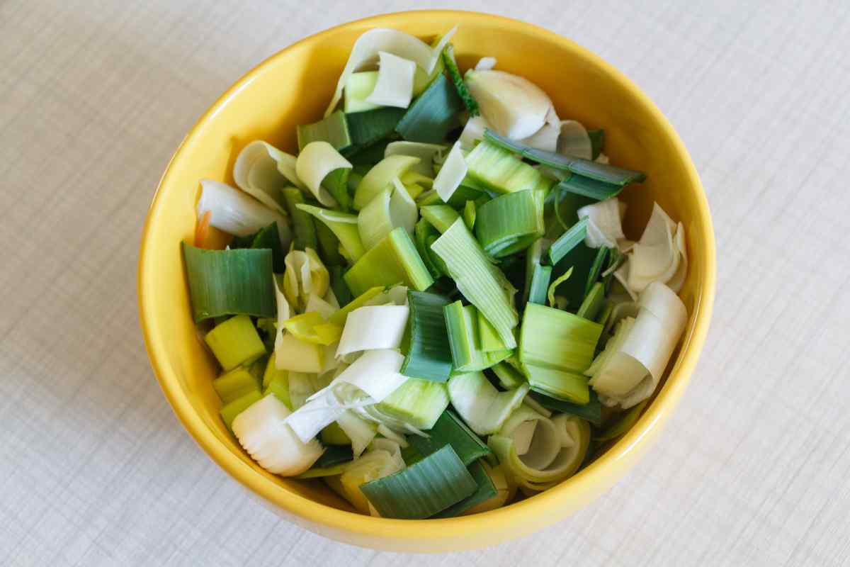 Image of some leeks chopped into half moon slices in a bowl, this is part of a blog about making a leek and cheese pasta recipe with kids